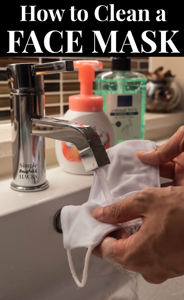 Closeup of a male hands washing his face mask with liquid soap and water.