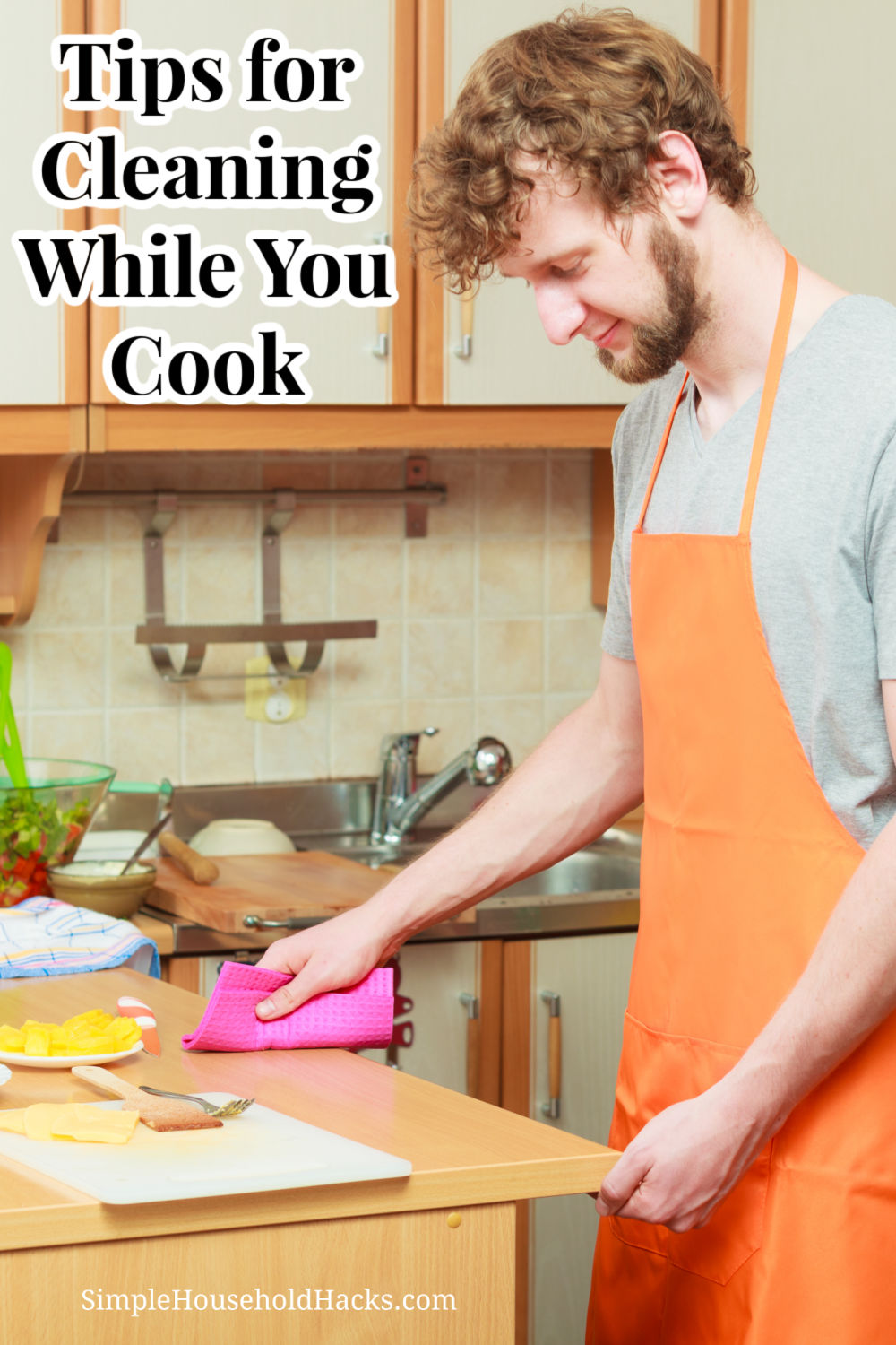 A man cleaning the counter while preparing a meal.